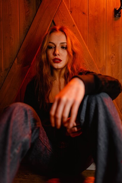 A woman leaning against a door. Therapy can be used to reshape internal dialogues 