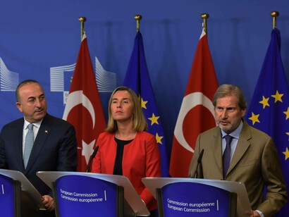 Turkish representative to the EU on the far left is listening to what his European counterpoint from the European Commission is saying regarding Turkey and the EU
