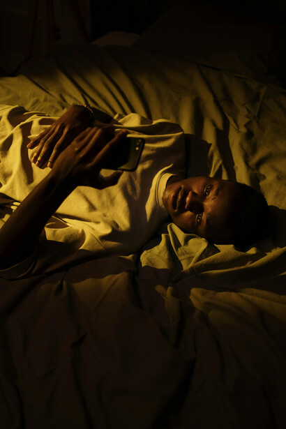 An anxious person scrolling on their phone at night, caught in a cycle of checking and reassurance