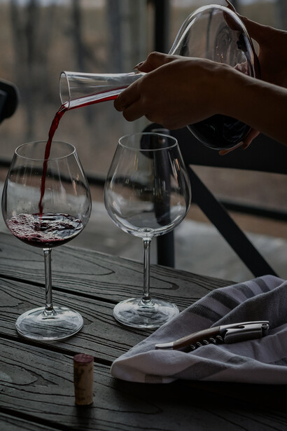 Someone skillfully filling a crystal-clear wine glass with wine
