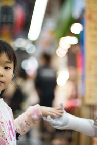 A young girl giving an AI robot the universally understood gesture of a high five