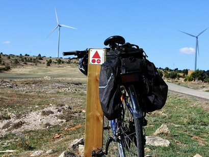 Una bicicleta apoyada en una de las señales del Camino del Cid