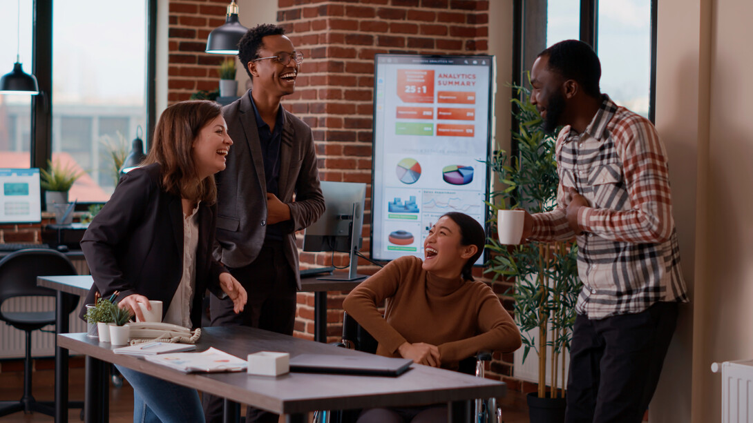 In an open office space, colleagues work together on a shared digital platform, reflecting how AI is transforming the way teams collaborate remotely, from anywhere in the world