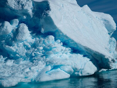 A towering Antarctic iceberg rising from the sea, representing the immense frozen reserves at the heart of the continent’s strategic importance