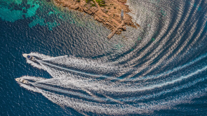 Luxury boats line the crystal-clear shores of Sardinia, Italy