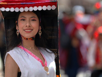 A young girl dressed in traditional attire joyfully participates in a vibrant festival in Cusco, Peru, showcasing the city's rich cultural heritage and festive spirit