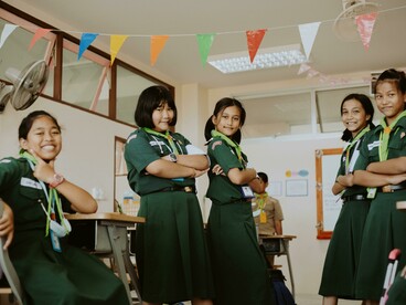 A diverse group of students wearing green school uniforms