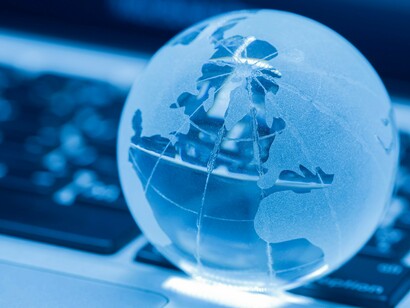 A close-up image of a frosted glass globe resting on a laptop keyboard that symbolizes the intersection of global business, technology, and law, emphasizing the transformation of legal norms into dynamic principles that integrate seamlessly into an ever-evolving global marketplace