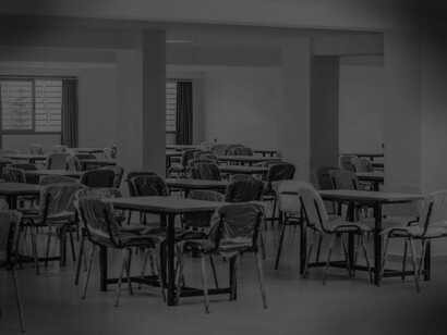 Chairs in a school cafeteria are still wrapped in plastic since this is the new normal and no one is expected to return to them in the foreseeable future