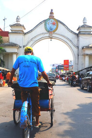 The vibrant streets of Solo, Indonesia, come alive with the hustle and bustle of tuk-tuks, motorcycles, and pedestrians weaving through colorful markets and local vendors