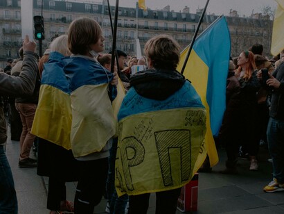 Two boys wrapped in the flag of Ukraine during an anti-war protest
