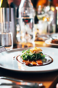 Gourmet meal with white wine on a white ceramic plate: European cuisine and food pairing for sensory dining experiences