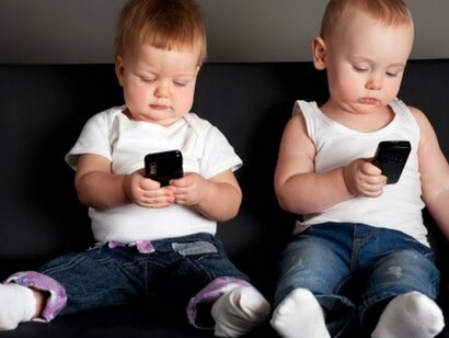 Dos bebés con teléfonos móviles