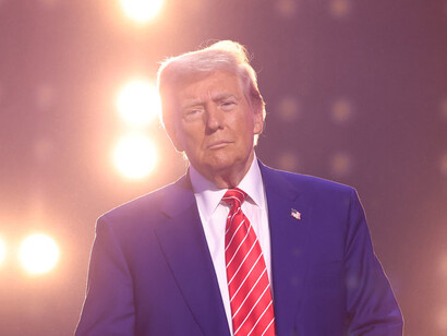 As the lights shine on him, Trump’s blank stare reflects the consequences of his decisions, which leave millions vulnerable to global health and climate threats