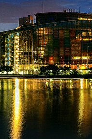 The European Union Parliament in Strasbourg, France, illuminated at night beside a body of water