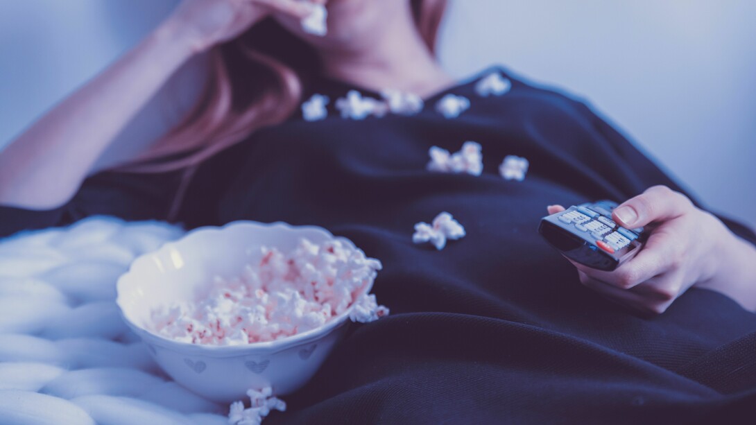 Woman watches tv with popcorn