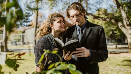 A grieving woman over the loss of a loved one on the shoulders of a priest