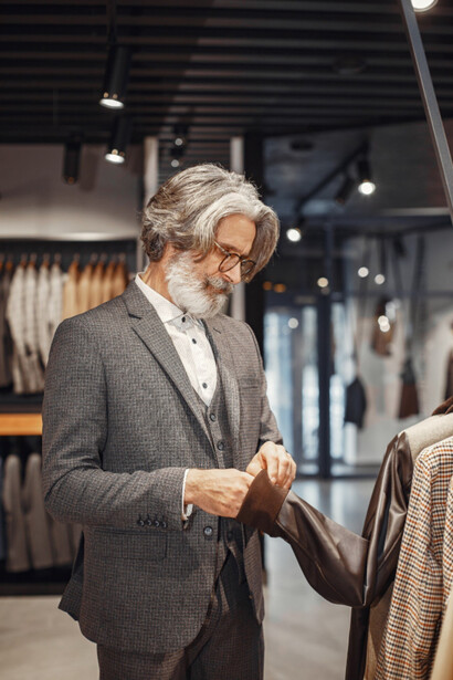 A man smiling over garment that blend Italian tradition and contemporary style
