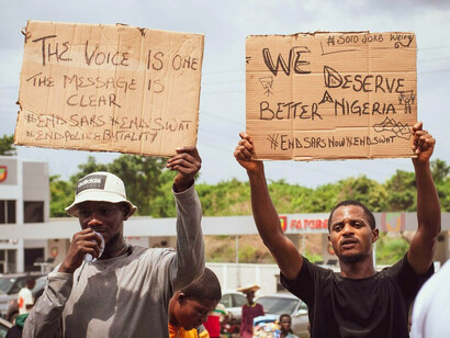 Protesters raising handwritten placards in defiance, representing the growing demand for accountable leadership in Africa