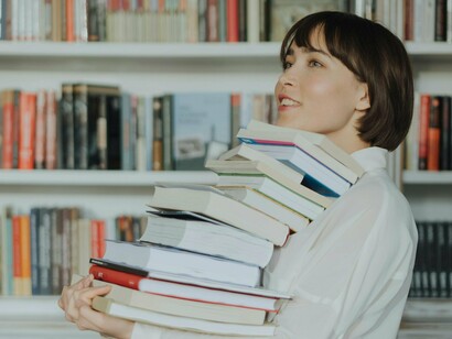 Mulher carrega suas próximas leituras. Será, pois, extremamente benéfico e propulsor de crescimento o facto nos “apropriarmos” do texto no sentido de revisitar o seu mundo, de nos autoquestionarmos e consciencializarmos o nosso lugar no mundo, as nossas fragilidades, as nossas potencialidades, enfim, enfrentar o palco dos conflitos interno