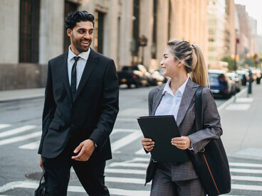 A husband and wife walking confidently toward their next destination, symbolising a partnership built on shared ambition and mutual encouragement