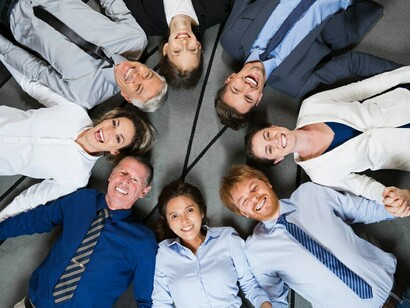 A business team celebrating together, symbolizing the power of corporate diversity, inclusion, and the intersectionality of social justice in the workplace