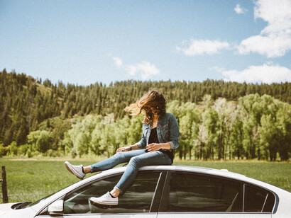 A girl sits alone on the top of a car, with her will as an instrument of change, of liberation