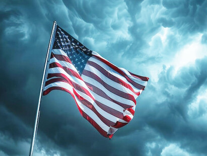 As the flag waves in the gusting wind, it mirrors the turbulence awaiting the U.S. in Trump’s second term, where instability and authoritarian impulses could redefine the nation’s course