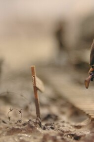 Soldier walking on wooden pathway surrounded with barbwire 