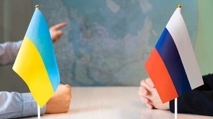 Ukrainian and Russian delegates sitting at a table negotiating a possible peacetalk 