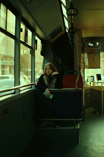 A blonde woman rides the bus alone during her commute