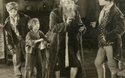Szene von „Oliver Twist“, Verfilmung aus dem Jahr 1922. Jackie Coogan (zweiter von  Links) verkörpert Oliver Twist im Film