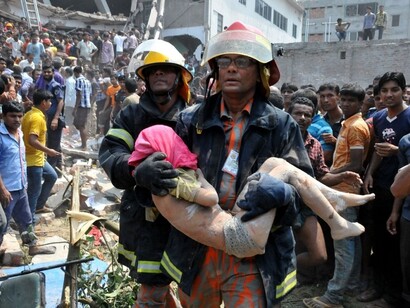 Un niño es evacuado tras el derrumbe del edificio Rana Plaza de Bangladesh en 2013, donde se elaboraba ropa para Primark, Benetton o El Corte Inglés, entre otros