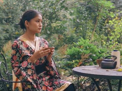 In the serene garden, she takes a moment to sip her tea, embracing the stillness that allows her to connect deeply with her thoughts and feelings