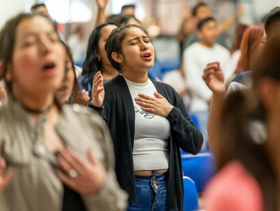 A gathering of faithful individuals in solemn worship, representing hope anchored in God despite adversity