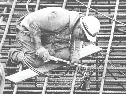 A worker welding on his job