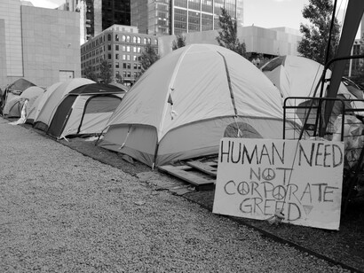 Protesters against corporate greed show how humans need, near encampments
