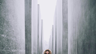 Joven mirando el cielo desde un bosque de mármol gris-negro, Memorial del holocausto, Berlin, Alemania