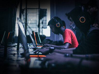 Jóvenes concentrados en sus ordenadores mientras juegan videojuegos