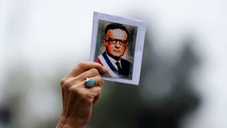 Una ciudadana chilena sostiene una pequeña fotografía del difunto presidente Salvador Allende