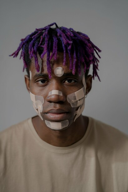 A person with plasters on their face. the idea of confirmation as verification and validation of what happens causes emptiness