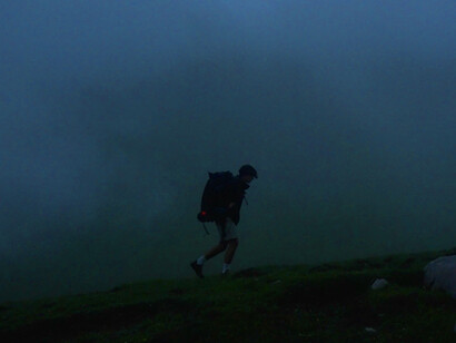 Amidst the misty peaks, a lone hiker navigates the rugged terrain, showcasing the solitude often found in the struggle for survival against overwhelming odds