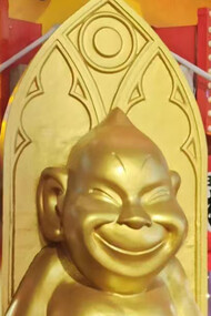 A golden statue of Billiken and his mischievous smile