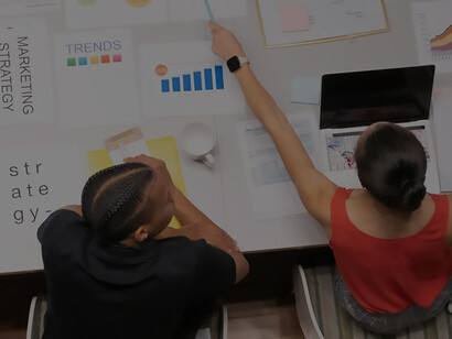 In a vibrant workplace setting, a woman collaboratively discusses business ideas over coffee with colleagues, illustrating teamwork and entrepreneurial spirit in action