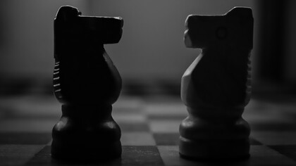A black-and-white photo of two chess pieces, symbolizing the ideological battle and power struggle between opposing forces in today's society