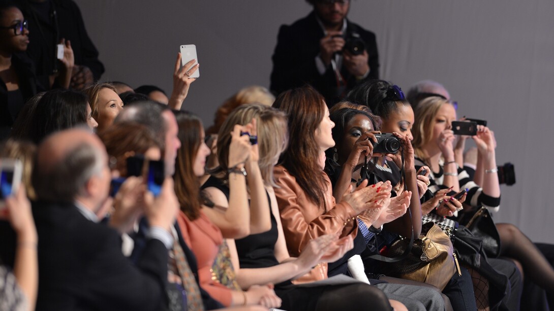 El público graba con sus cámaras y teléfonos móviles un desfile de moda
