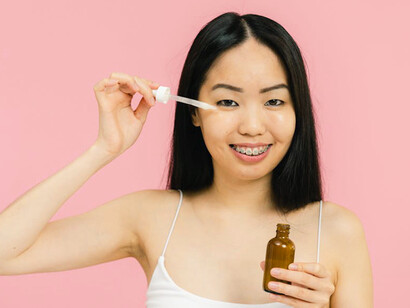 The woman massages ointment into her skin, reclaiming self-care rooted in South Asian traditions co-opted by Western wellness trends