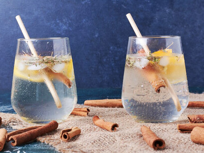 A slice of lemon and cinnamon beside a cup of soda, highlighting the health consequences of sugary drink consumption
