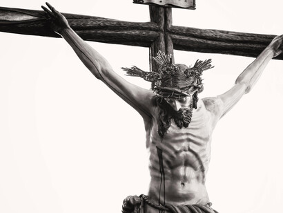 Grayscale image showing a detailed crucifix of Jesus inside a historic church in Carmona, Andalusia, Spain