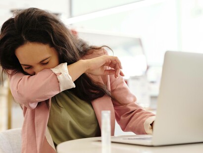 Woman coughing into her shirt